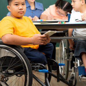 Criança em cadeira de rodas em sala de aula